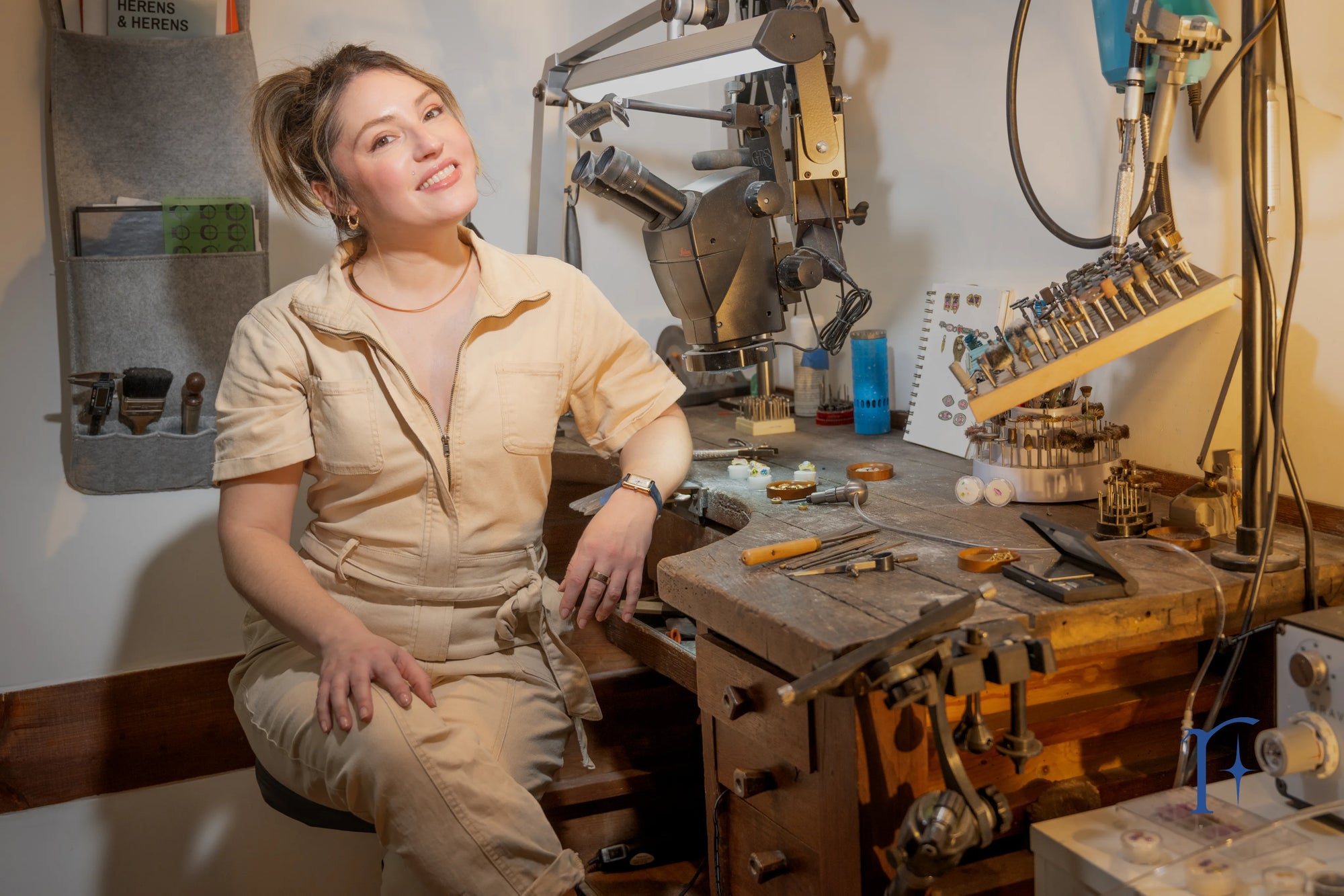 A portrait of the artist behind Ruinette, Jamie Roth, pictured in her studio at a jewelry bench with tools. 