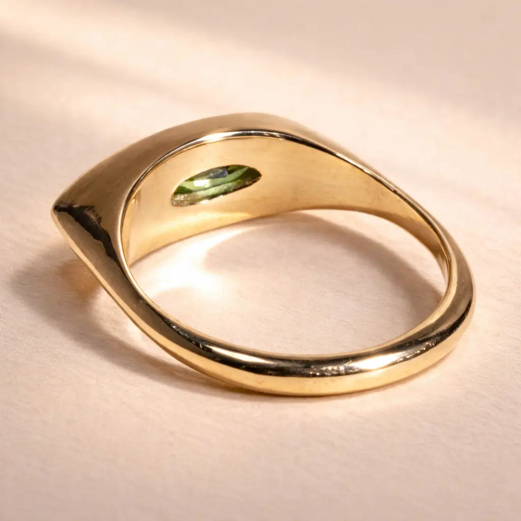 Ruinette Kitty Cat Ring I in 18k yellow gold shown from back angle, displaying smooth polished band with marquise peridot stone visible from inside